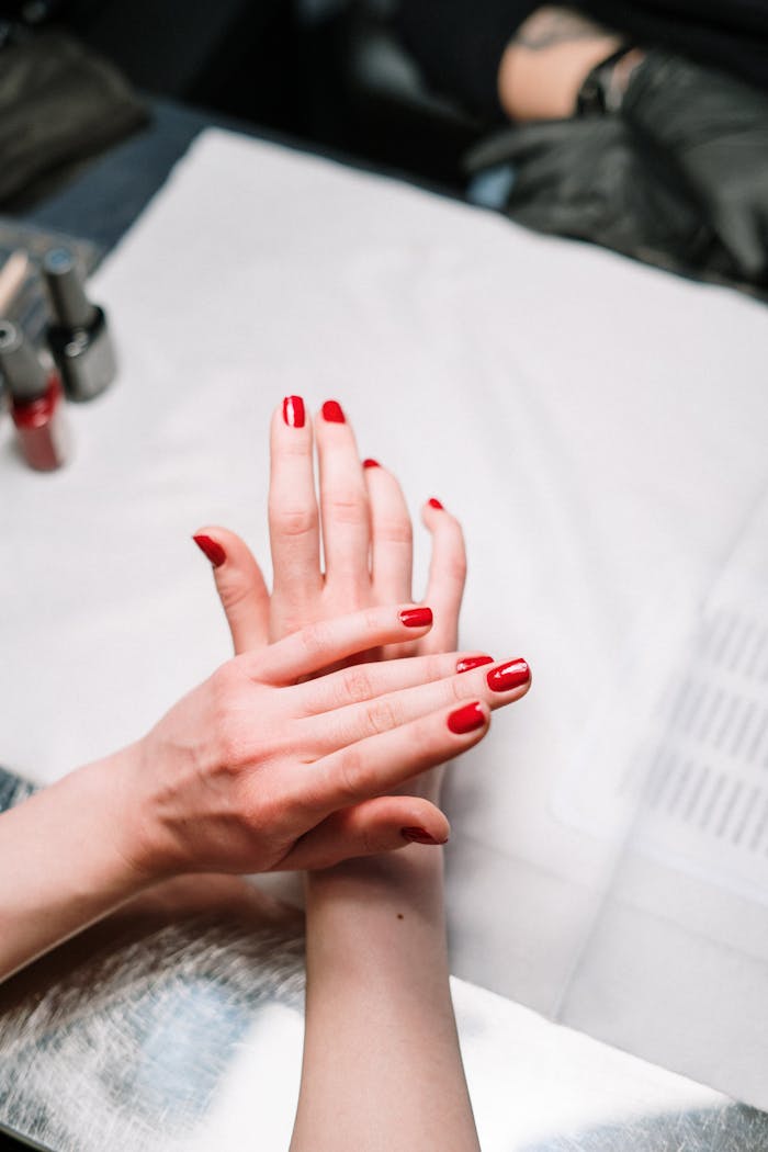 gallery-04 Professional hand treatment features a stylish red manicure at a modern nail salon.