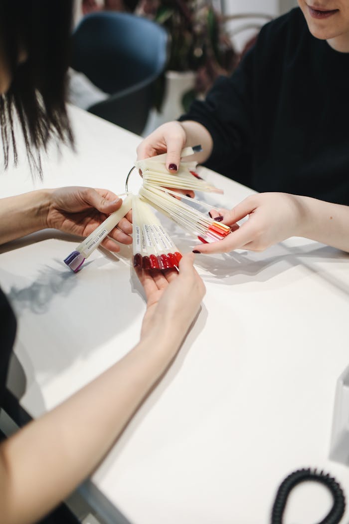 gallery-05 Customer selecting nail polish color at a salon from a sample set.