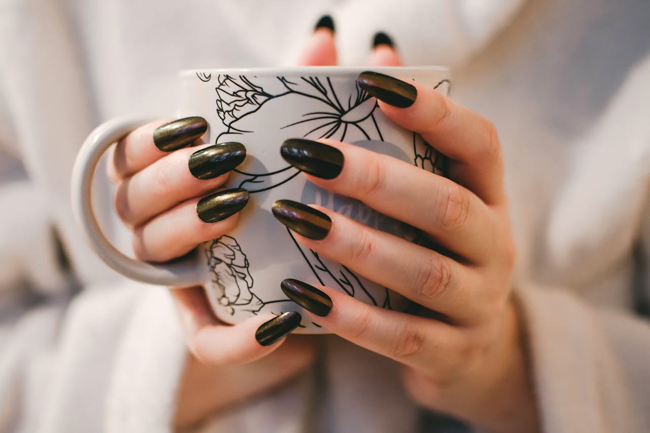 our-story A close-up of manicured hands holding a decorative mug, perfect for lifestyle and coffee themes.
